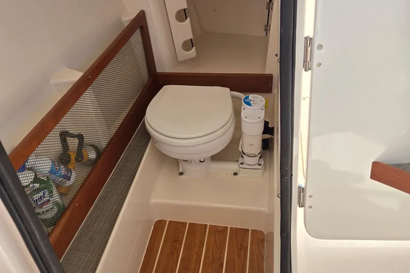 Slide: The Image of 2016 Grady-White Freedom 275 boat interior with compact marine toilet. - 13
