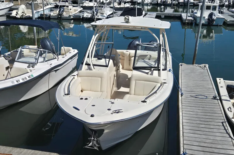 Slide: The Image of 2016 Grady-White Freedom 275 boat docked at marina, featuring sleek design and spacious seating. - 2