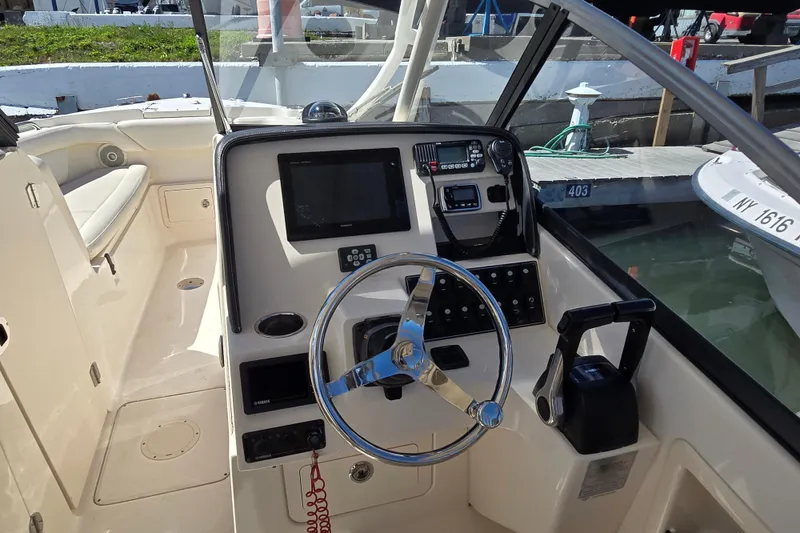 Slide: The Image of 2016 Grady-White Freedom 275 boat helm with steering wheel and control panel. - 3