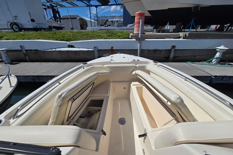 Slide: The Image of 2016 Grady-White Freedom 275 boat interior with seating and storage at a marina. - 6