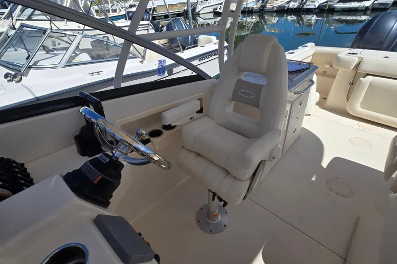 Slide: The Image of 2016 Grady-White Freedom 275 boat interior with steering wheel and captain's chair. - 7