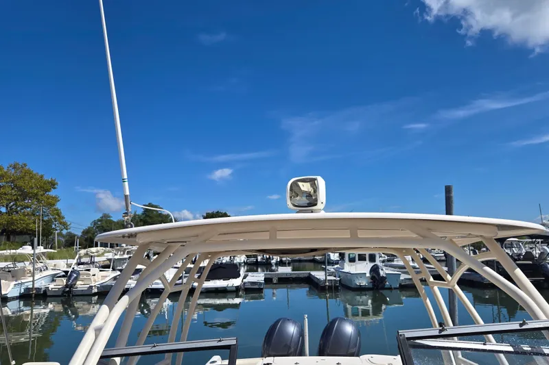 Slide: The Image of 2016 Grady-White Freedom 275 boat docked in a marina under clear blue sky. - 8