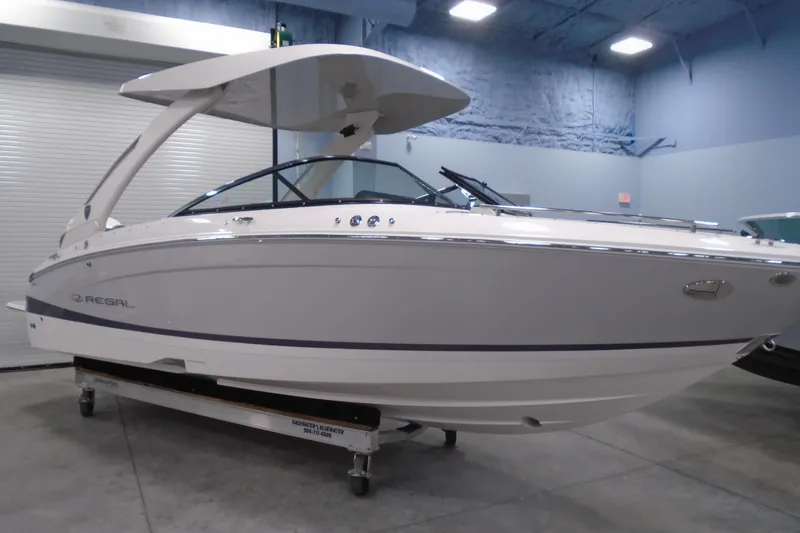 Slide: The Image of 2026 Regal LX4 boat in showroom, featuring sleek design and modern canopy. - 23