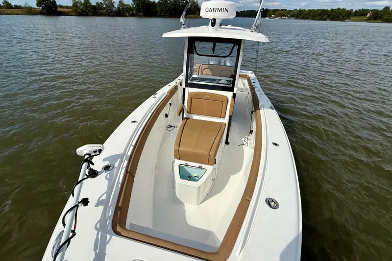 Slide: The Image of 2021 Sea Hunt Gamefish 27 Coffin Box boat on calm water, featuring Garmin equipment. - 15