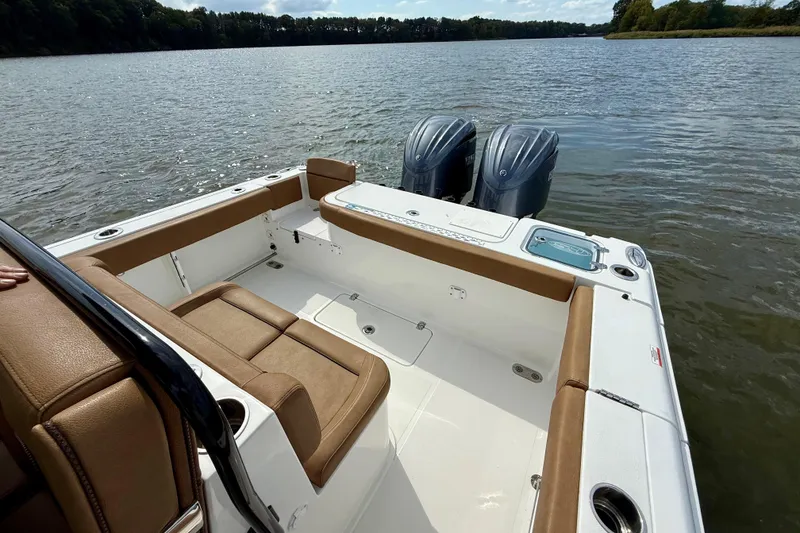 Slide: The Image of 2021 Sea Hunt Gamefish 27 Coffin Box boat interior with twin engines on a calm lake. - 24