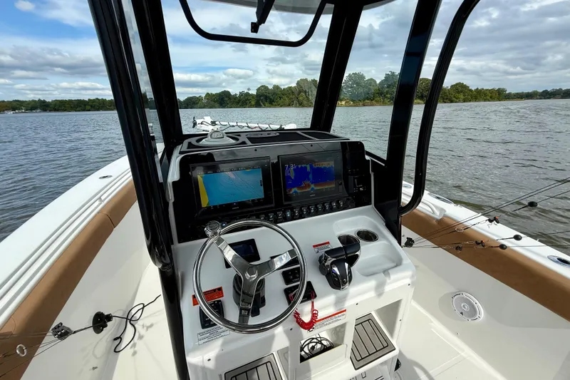 Slide: The Image of 2021 Sea Hunt Gamefish 27 Coffin Box boat dashboard with navigation screens on a lake. - 25