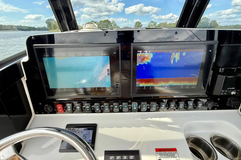 Slide: The Image of 2021 Sea Hunt Gamefish 27 dashboard with dual Garmin displays and control panel. - 27