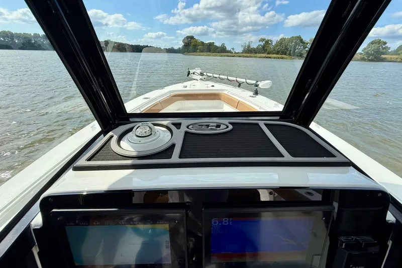 Slide: The Image of 2021 Sea Hunt Gamefish 27 Coffin Box boat dashboard view on a calm lake. - 28