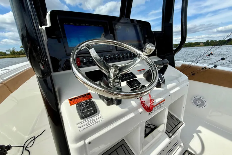 Slide: The Image of 2021 Sea Hunt Gamefish 27 Coffin Box helm with steering wheel and navigation screens. - 29