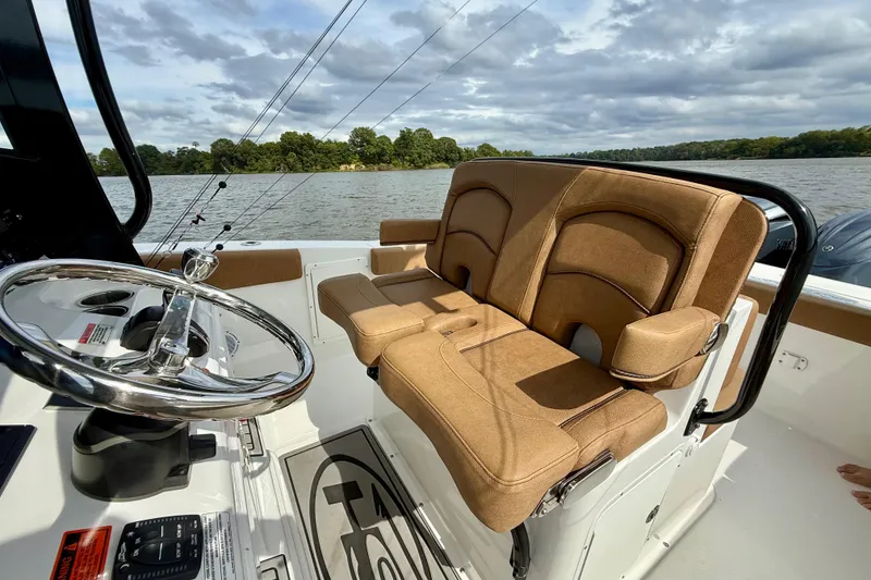 Slide: The Image of 2021 Sea Hunt Gamefish 27 Coffin Box boat interior with tan seating and steering wheel. - 30