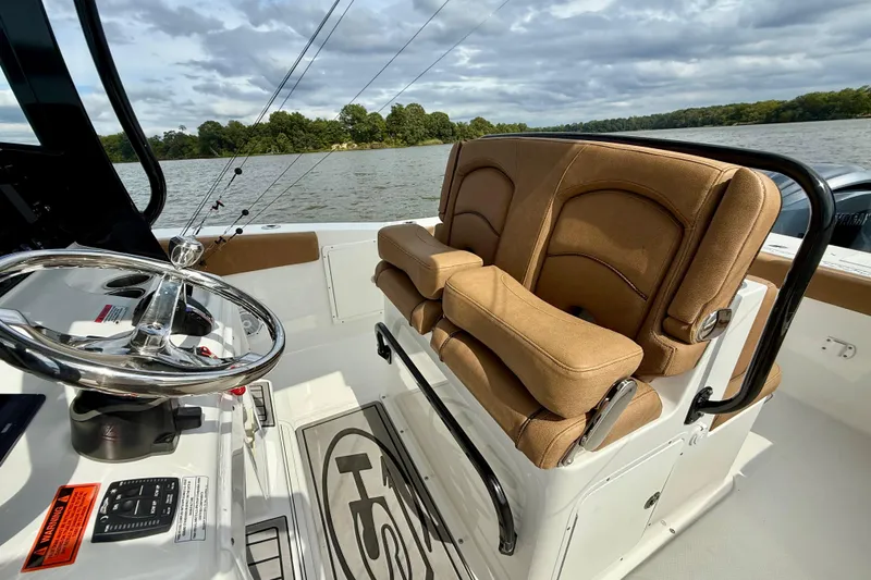 Slide: The Image of 2021 Sea Hunt Gamefish 27 Coffin Box boat interior with tan seating and steering wheel. - 31