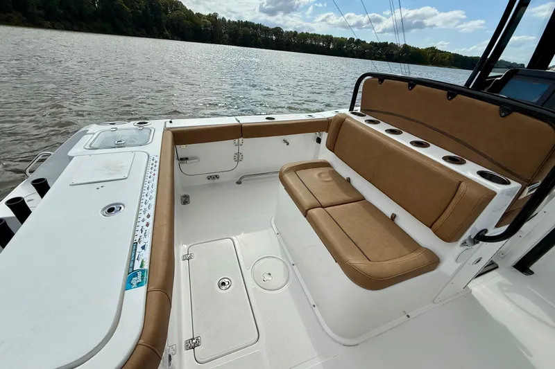 Slide: The Image of 2021 Sea Hunt Gamefish 27 Coffin Box boat interior with tan seating and rod holders. - 37