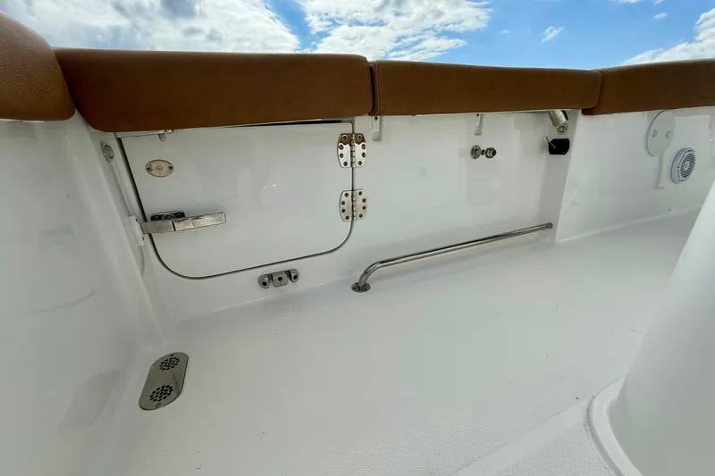Slide: The Image of 2021 Sea Hunt Gamefish 27 Coffin Box interior with brown seating and white deck. - 38