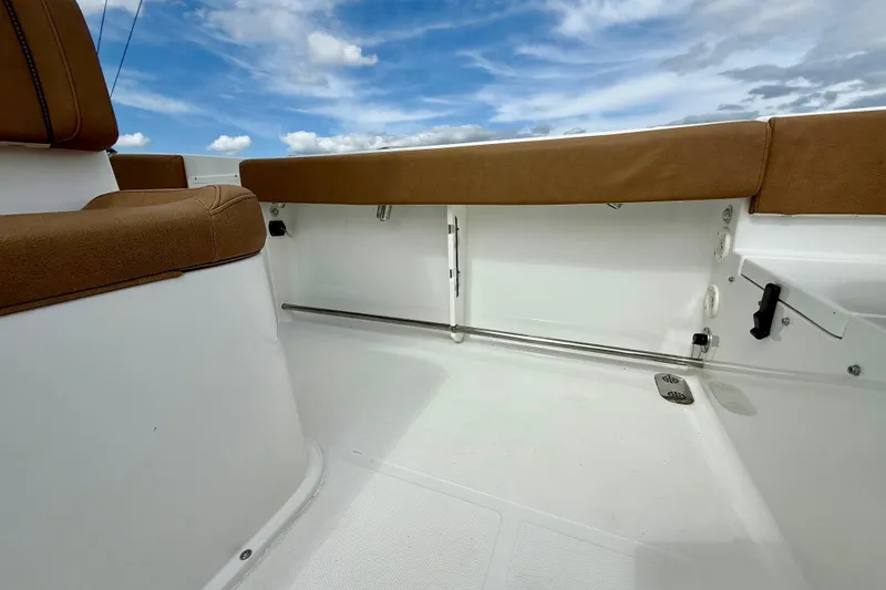 Slide: The Image of 2021 Sea Hunt Gamefish 27 Coffin Box interior with brown seating under blue sky. - 39