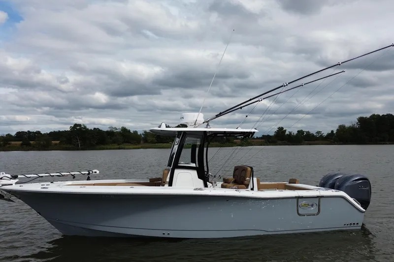 Slide: The Image of 2021 Sea Hunt Gamefish 27 Coffin Box boat on a calm lake under cloudy skies. - 4