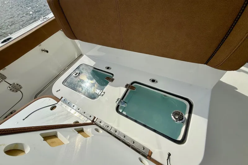 Slide: The Image of 2021 Sea Hunt Gamefish 27 Coffin Box interior with brown seating and storage compartments. - 40