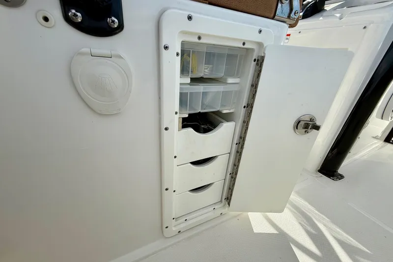 Slide: The Image of 2021 Sea Hunt Gamefish 27 Coffin Box storage compartment with open door and organized trays. - 41