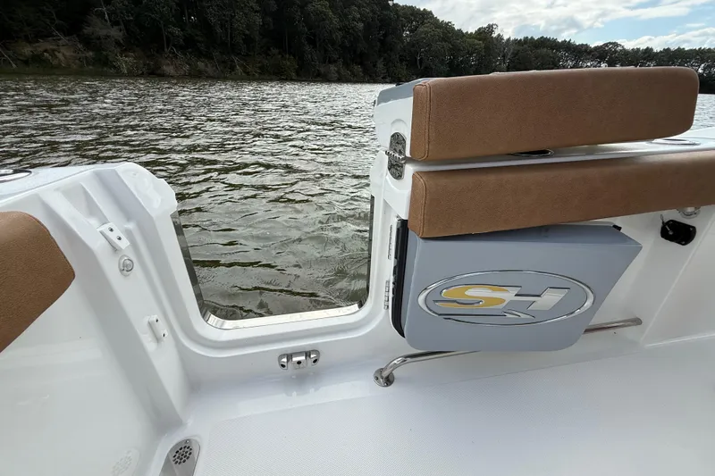 Slide: The Image of 2021 Sea Hunt Gamefish 27 Coffin Box boat interior with open side door on a lake. - 55