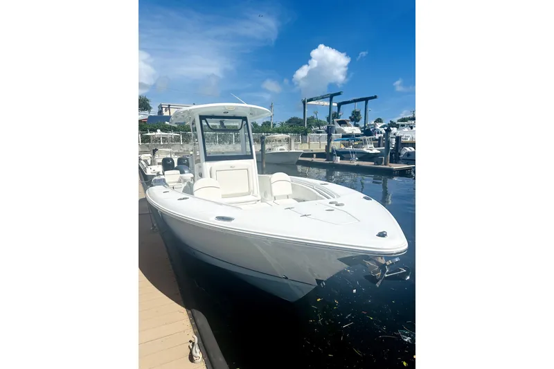 Slide: The Image of 2020 Sea Hunt Gamefish 27 Forward Seating boat docked under clear blue sky. - 2
