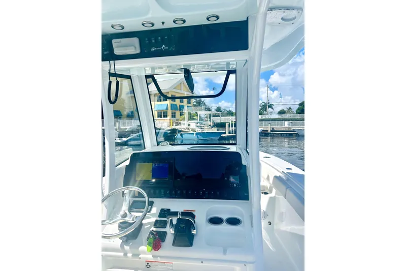 Slide: The Image of 2020 Sea Hunt Gamefish 27 helm with modern controls and navigation, docked at marina. - 8