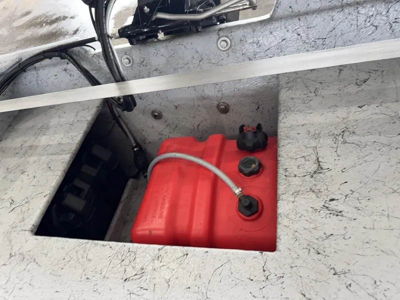Slide: The Image of Red fuel tank in a 2022 Custom Reno Skiff 16 boat compartment. - 11