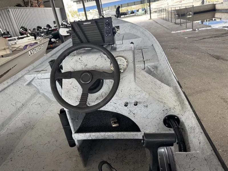 Slide: The Image of Interior of a 2022 Custom Reno Skiff 16 boat with steering wheel and navigation equipment. - 9