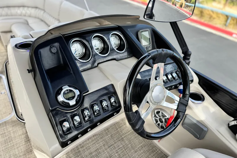 Slide: The Image of 2015 Bennington 2575 QCW boat dashboard with steering wheel and control panel. - 31