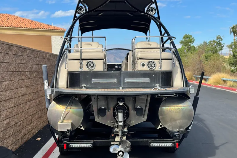 Slide: The Image of 2015 Bennington 2575 QCW pontoon boat rear view, parked on a sunny day. - 5
