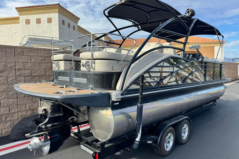 Slide: The Image of 2015 Bennington 2575 QCW pontoon boat on trailer, parked outdoors. - 6