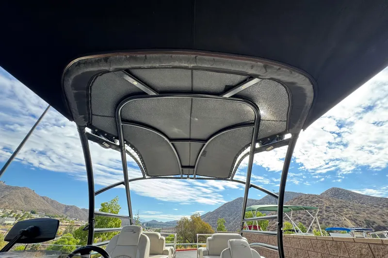 Slide: The Image of 2015 Bennington 2575 QCW boat canopy with scenic mountain and sky backdrop. - 9
