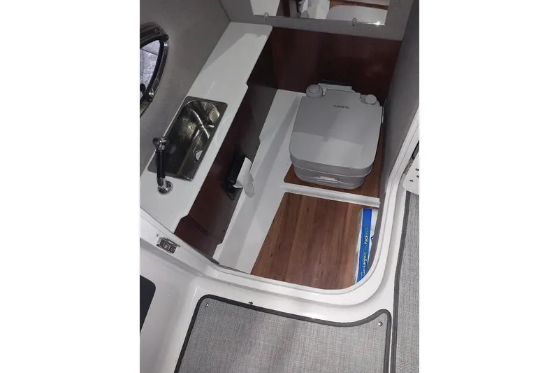 Slide: The Image of 2021 Chaparral 267 SSX boat interior with sink and portable toilet. - 11