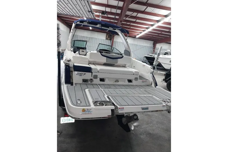 Slide: The Image of 2021 Chaparral 267 SSX boat in a warehouse, rear view showing deck and seating. - 3
