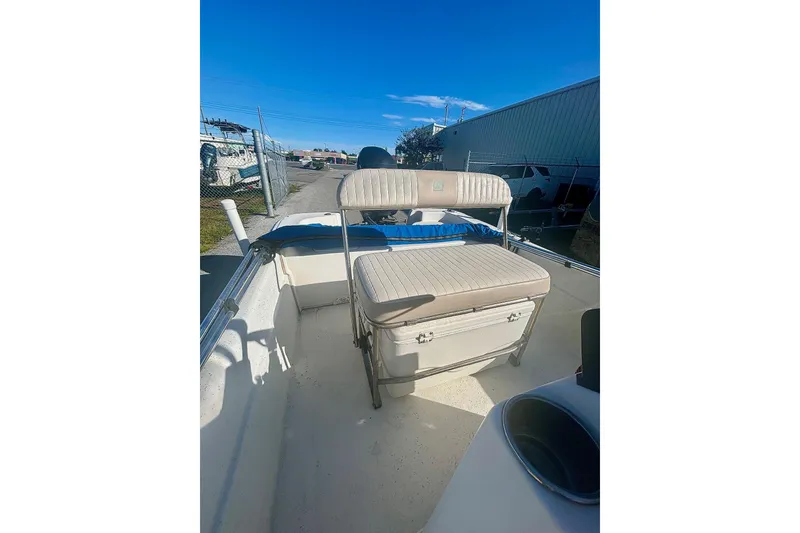 Slide: The Image of 2014 Carolina Skiff JVX18CC boat interior with seating and storage, parked outdoors. - 6
