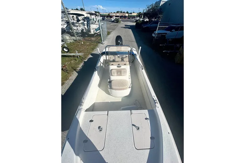 Slide: The Image of 2014 Carolina Skiff JVX18CC boat, white interior, parked outdoors in a marina setting. - 7