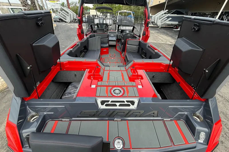 Slide: The Image of 2026 Supra SE 550 boat interior with red and gray design, open storage compartments. - 10