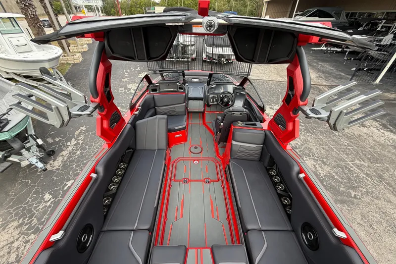 Slide: The Image of 2026 Supra SE 550 boat interior with sleek red and gray design, spacious seating, and advanced features. - 12