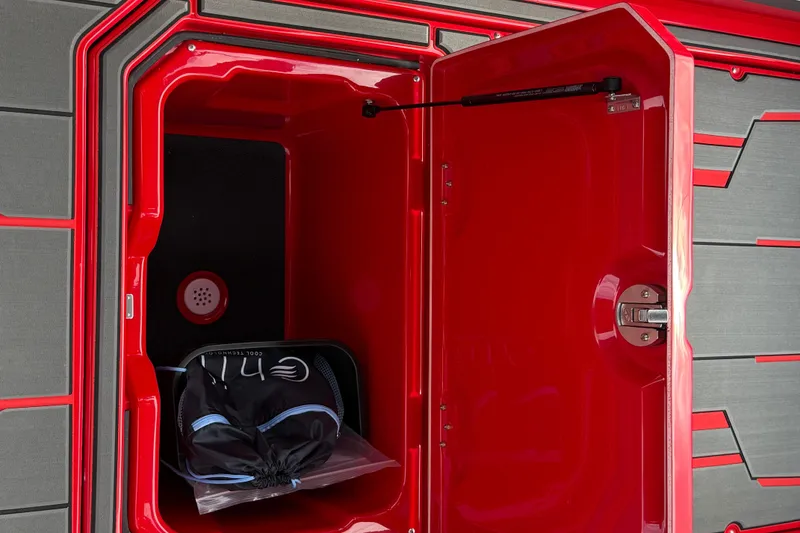Slide: The Image of Red storage compartment in 2026 Supra SE 550 boat, featuring sleek design and secure latch. - 19