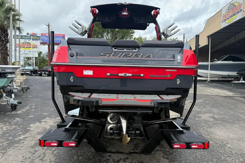 Slide: The Image of 2026 Supra SE 550 boat, rear view, red and black design, parked at South Austin Marine. - 5