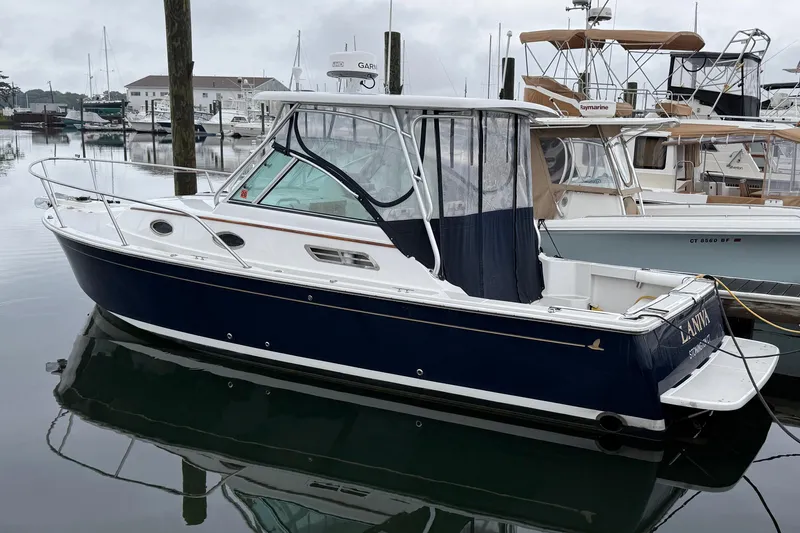 The Image of 2005 Back Cove 26 boat docked in a marina, featuring a sleek design. - 0