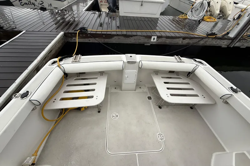 Slide: The Image of 2005 Back Cove 26 boat interior with seating and dock view. - 12