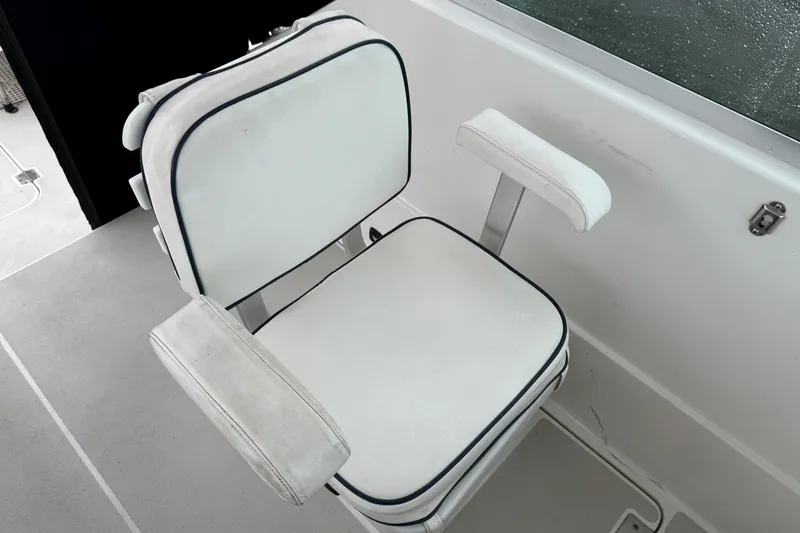Slide: The Image of White captain's chair on 2005 Back Cove 26 boat, featuring cushioned armrests. - 22