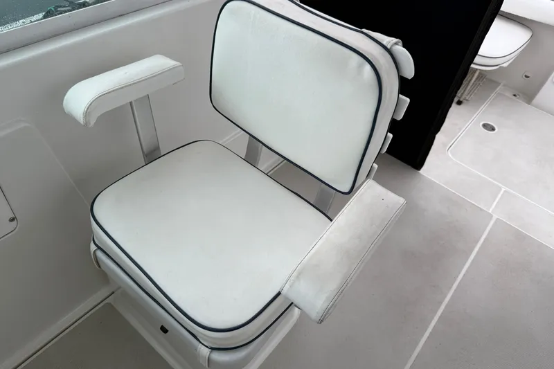 Slide: The Image of White cushioned seat on 2005 Back Cove 26 boat, featuring armrests and clean design. - 23