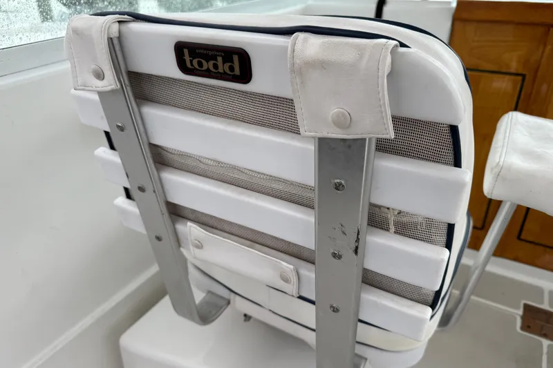 Slide: The Image of Back Cove 26 (2005) boat seat with Todd Enterprises branding, featuring white cushioned design. - 25
