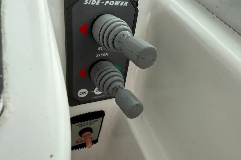 Slide: The Image of Control panel of a 2005 Back Cove 26 boat with thruster levers. - 32