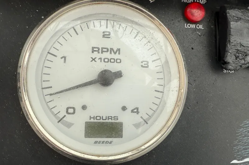 Slide: The Image of Close-up of a 2005 Back Cove 26 RPM gauge with hour meter and warning lights. - 37