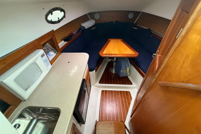 Slide: The Image of 2005 Back Cove 26 interior with kitchenette, sink, and cozy seating area. - 44