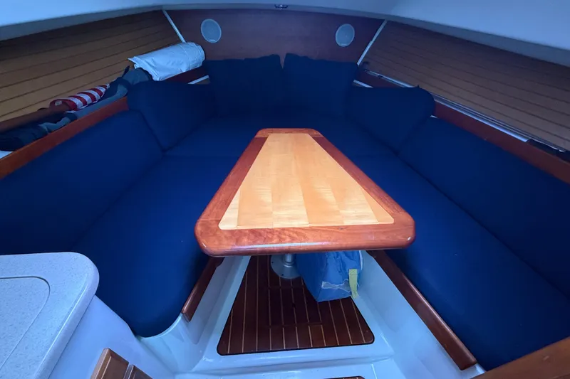 Slide: The Image of 2005 Back Cove 26 interior with blue seating and wooden table in cabin. - 46