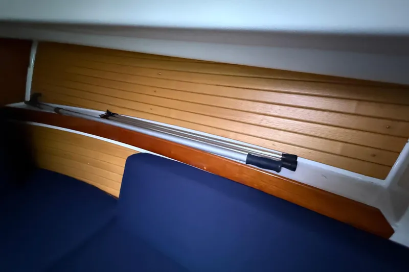 Slide: The Image of Interior of 2005 Back Cove 26 boat with wooden paneling and blue seating. - 48