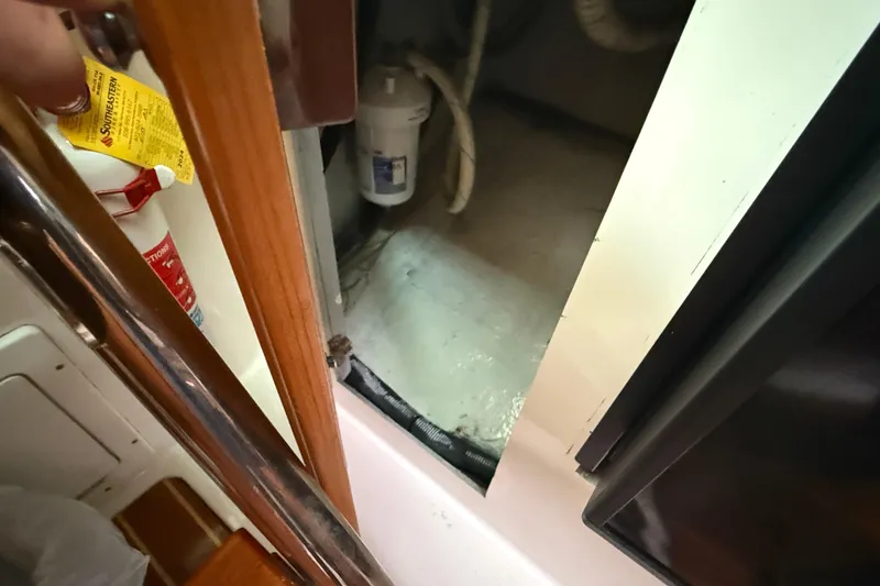 Slide: The Image of Interior view of a 2005 Back Cove 26 boat, showing storage compartment and fire extinguisher. - 56