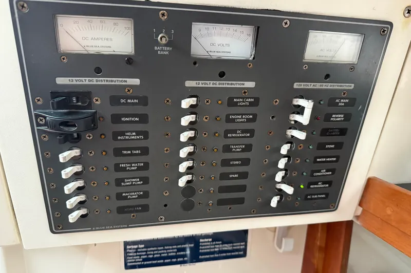Slide: The Image of Electrical panel of a 2005 Back Cove 26 boat, featuring DC and AC distribution controls. - 57
